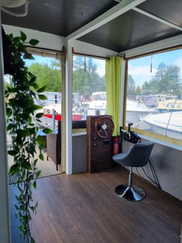 a room with a chair and a desk and windows at Floss Priepert 1 in Priepert