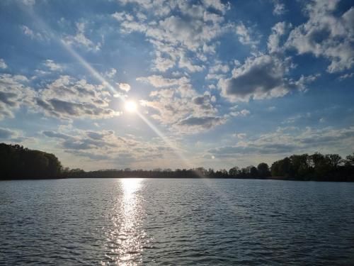 a view of a lake with the sun in the sky at Floss Priepert 1 in Priepert