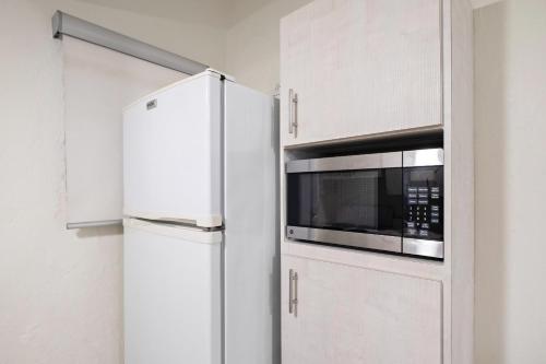 a kitchen with a white refrigerator and a microwave at Prime Location at Condado Beach 1br 1ba - Apt 8 in San Juan