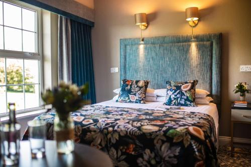 a bedroom with a bed with a blue headboard at Falls Hotel & Spa in Ennistymon