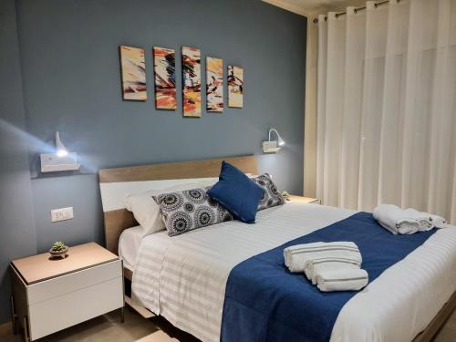 um quarto com uma cama grande com lençóis e almofadas azuis em Ro agrimaison em Volla