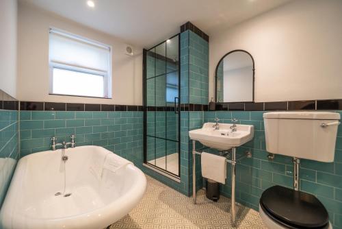 a bathroom with a sink and a tub and a toilet at Kestrel Cottage at Seven Sisters Country Park in West Dean