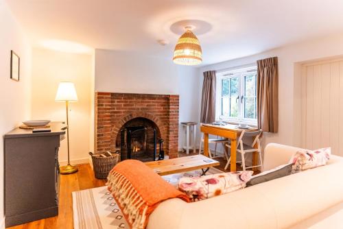 a living room with a couch and a fireplace at Kestrel Cottage at Seven Sisters Country Park in West Dean