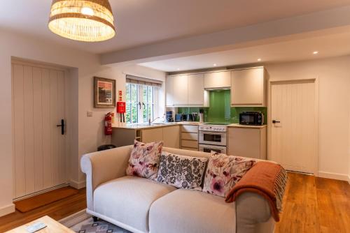 a living room with a couch and a kitchen at Kestrel Cottage at Seven Sisters Country Park in West Dean