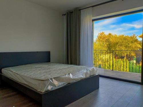 a bedroom with a bed and a large window at Casa Brad in Braşov