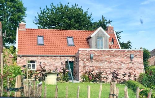 a brick house with a red roof at Haus Deichkind in Krummhörn