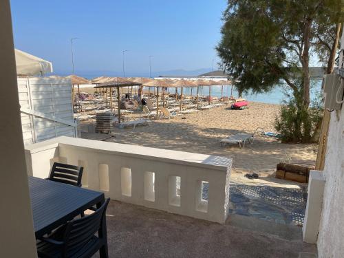 a beach with a white fence and a table and chairs at Fishermen Beach House in Dhiakofti