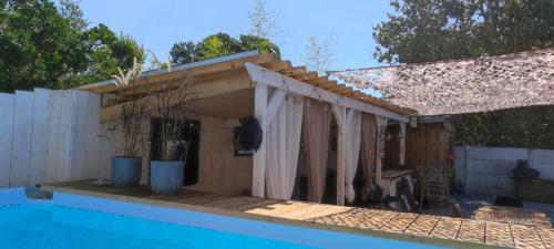 une maison située à côté d'une piscine dans l'établissement Villa Mermoz andernos, à Andernos-les-Bains