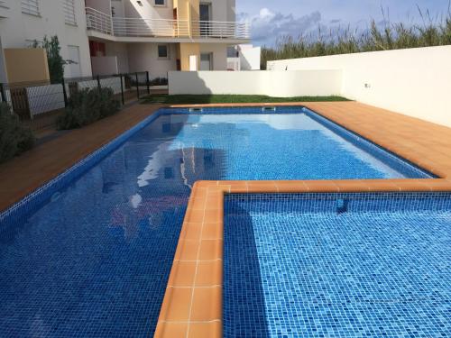 a swimming pool with blue tiles on top of a house at Paradise Apartments in Baleal