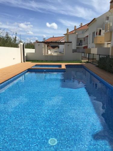 a swimming pool in front of a house at Paradise Apartments in Baleal
