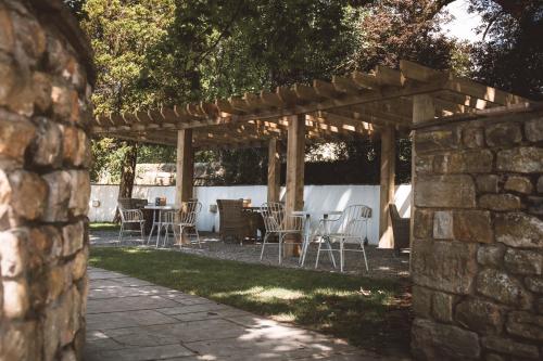a patio with tables and chairs under a wooden pergola at The Waddington Arms in Waddington