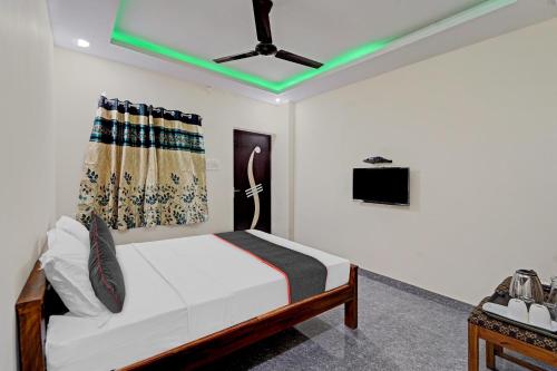 Super Townhouse 1096 Hotel Redfox Nungambakkam Near Apollo & Shankar Nethralaya Hospital في تشيناي: غرفة نوم مع سرير ومروحة سقف