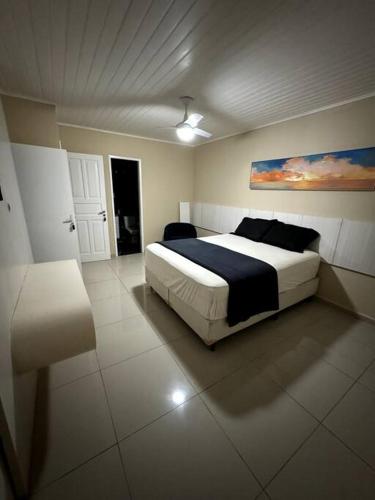 ein Schlafzimmer mit einem Bett und einem Wandgemälde in der Unterkunft Casa com Piscina ao lado do Shopping in Cabo Frio