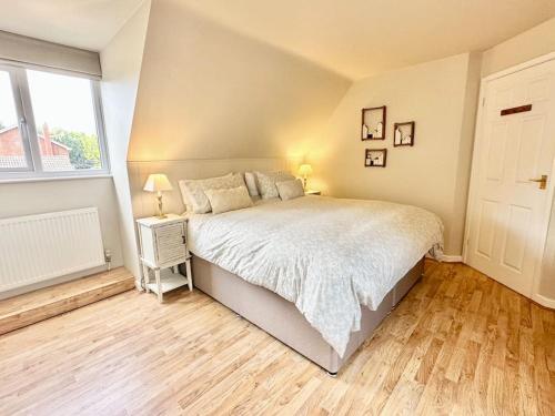 Un dormitorio con una cama grande y una ventana en Greenacre Lodge - cosy, dog-friendly rural home with private garden, en Redgrave