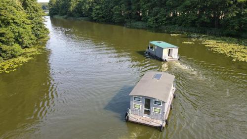 two boats in a river with a house on it at Floss Priepert 2 in Priepert