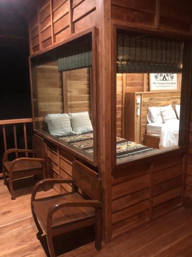 a room with two bunk beds and a chair at The Tropical Koh Mook in Koh Mook