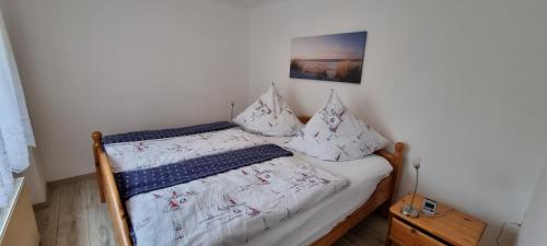 ザスニッツにあるFerienwohnung Kollwitzの小さなベッドルーム(白いシーツと枕のベッド付)
