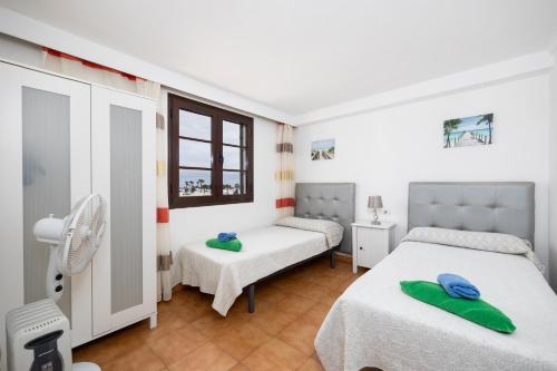 プエルト・デル・カルメンにあるVilla Bellamarのベッドルーム1室(ベッド2台、窓付)