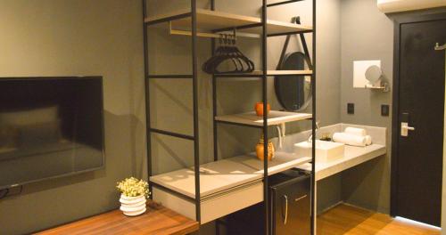 a glass shelving unit in a room with a sink at Nord One in João Pessoa