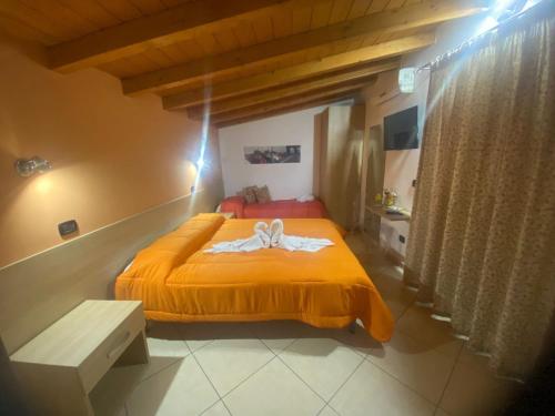 1 dormitorio con 1 cama con colcha amarilla en MANDANICI :Borgo Marsalini 2.0, en Barcellona-Pozzo di Gotto