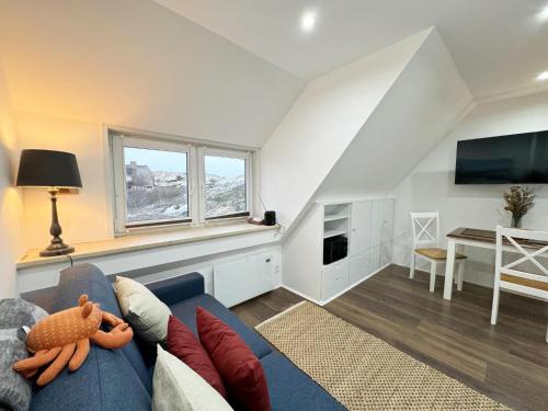 een woonkamer met een blauwe bank en een tv bij Ferienwohnung zwischen den Dünen in Rantum
