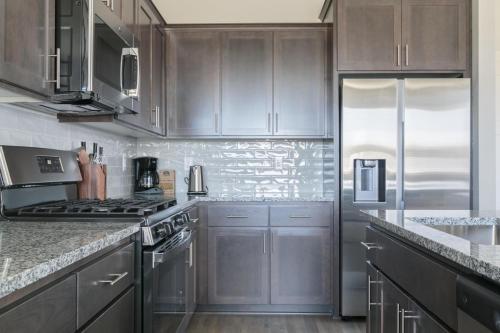 a kitchen with stainless steel appliances and wooden cabinets at Hillsboro 2br close to park restaurants PDX-8 in Aloha
