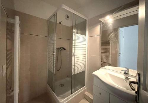 uma casa de banho com uma cabina de duche em vidro e um lavatório. em Appartement piscine/tennis em Mandelieu-la-Napoule