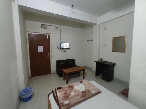 Zimmer mit einem Bett, einem Tisch und einer Tür in der Unterkunft New Hotel Labbaik in Dhaka