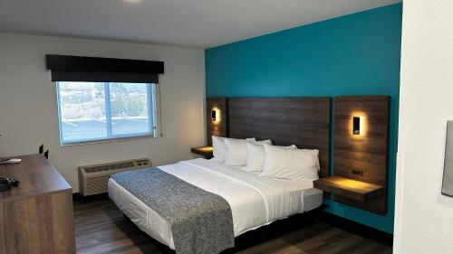 a bedroom with a large bed with a blue wall at The Copper Hotel - SureStay Collection by Best Western in Camp Verde