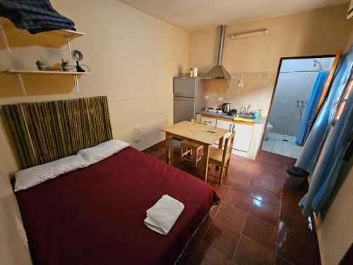 a bedroom with a bed and a table and a kitchen at La San Francisco III in Salta