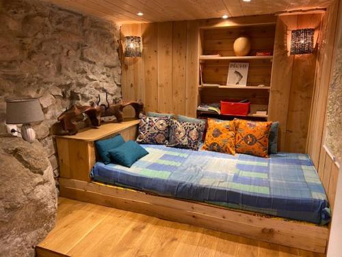 a bed in a room with a stone wall at Gîte du Grand Taïchou in Luzenac