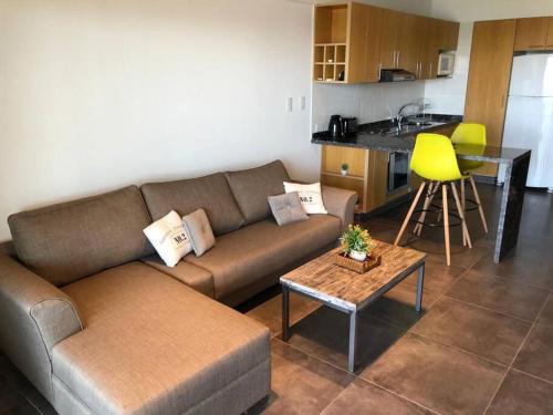 sala de estar con sofá, mesa y cocina en Inigualable vista en Los Molinos in 