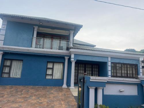 a blue house with a balcony at Luband Guest House in KuMcogwaba
