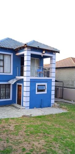 a blue and white house with a balcony at Luband Guest House 