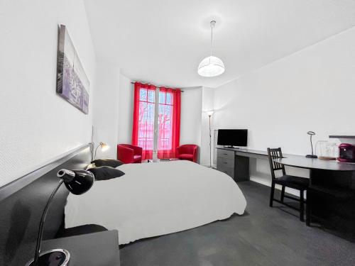 - une chambre avec un lit blanc, un bureau et une table dans l'établissement Le Nid Thermal, à Vichy