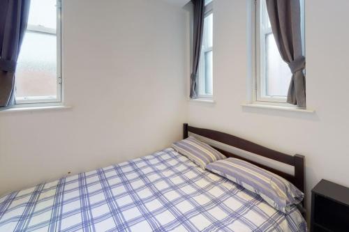 a bed in a bedroom with two windows at Quiet but Central Studio 409 in Nottingham
