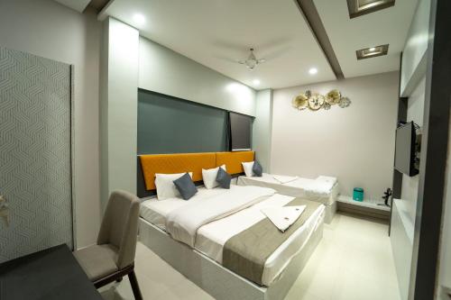 a bedroom with two beds and a chair in it at HOTEL PARK VIEW VILLA in Jodhpur