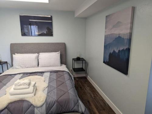a bedroom with a bed with two towels on it at Cottage near restaurants and trails Slumber Village 5 in Anchorage