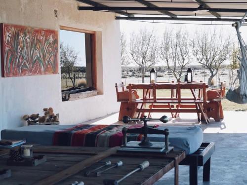 a room with two beds and a table and a window at Estancia TATAY in Trelew