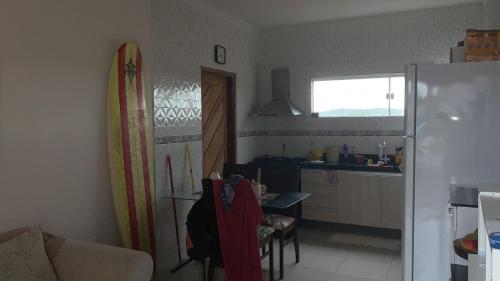 eine Küche mit einem Kühlschrank und einem Surfbrett an der Wand in der Unterkunft Casa dos Pirineus in Tibau do Sul