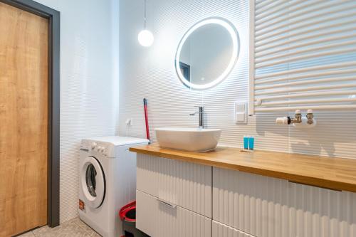 a bathroom with a sink and a washing machine at Ceglana Green Studio in Katowice