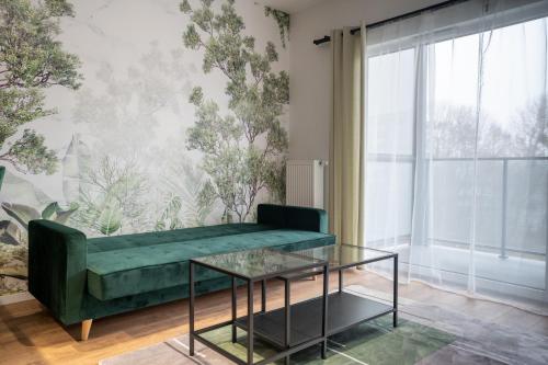 a living room with a green couch and a glass table at Ceglana Green Studio in Katowice