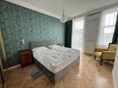 ein Schlafzimmer mit einem Bett und einer grünen Wand in der Unterkunft Ady1 Apartment in Kaposvár