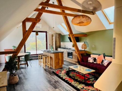 a living room with a couch and a table at La Rose des Vents - Appartement avec Terrasse, Piscine et Parking in Lautenbach