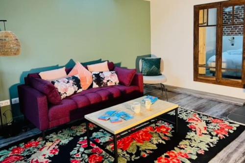 a living room with a purple couch and a coffee table at Appartement La Rose des Vents in Lautenbach