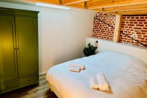 a bedroom with a bed with two towels on it at Appartement La Rose des Vents in Lautenbach