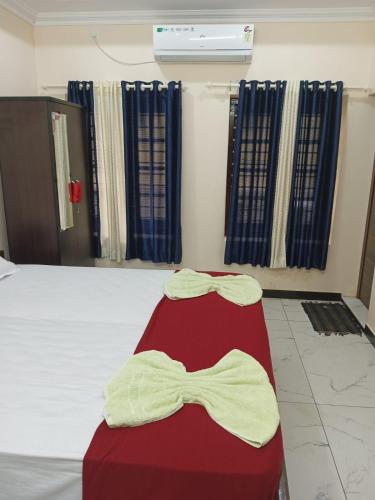 a bed with a red seat with a bow tie on it at SRI PADMANABHA TOURIST HOME in Chacka