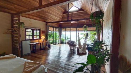 a living room with wooden ceilings and a room with plants at Why Nam Beach in Haad Yuan