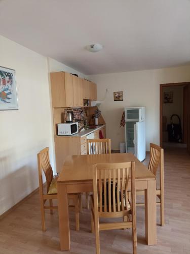 a kitchen and dining room with a wooden table and chairs at Magical apartment in Marina view Fort beach in Sveti Vlas