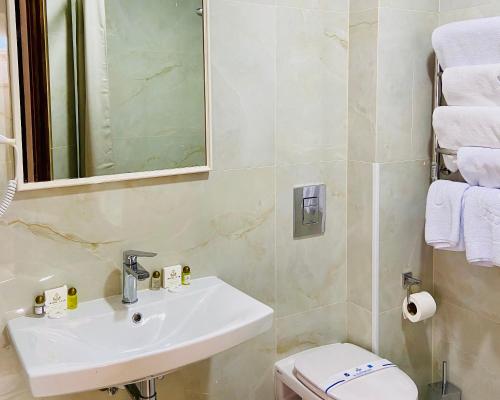 a bathroom with a sink and a toilet at Hotel Star in Mukacheve